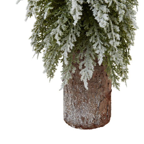 small snowy fir tree on tall wood log