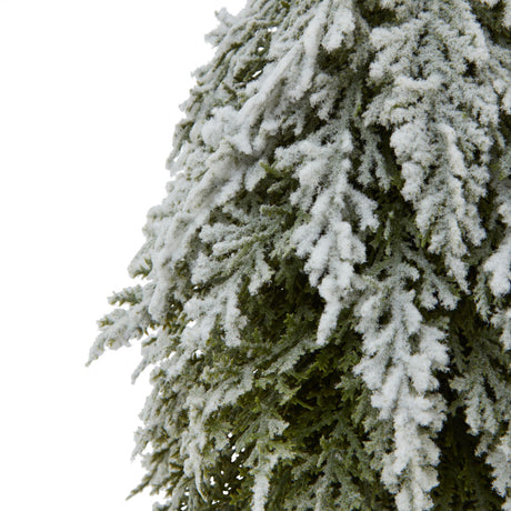 small snowy fir tree on tall wood log
